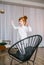 Funny redhead little girl dancing on chair at home