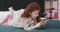 Funny redhead little girl with yellow smartphone lies on the bed and using smartphone. Communication, playing, app.