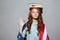 Funny redhead young lady holding book on head wearing USA flag