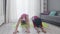 Funny retro style couple of Caucasian man and afro woman doing child`s yoga pose at home