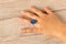 Funny ring on a little girl`s hand.  on wooden background