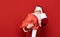 Funny Santa with a bag carries gifts for Christmas, studio portrait.Portrait of a tired Santa Claus with a bag in his hands on a