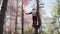 Funny Santa Claus suit with medical mask on his face climbed tree in forest and stands with colored smoke Christmas coronavirus