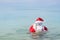 Funny Santa is swimming in the sea. Christmas in the tropics