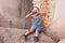 Funny screaming little boy sitting on a breakwater on a pier