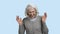 Funny senior woman is laughing on blue background