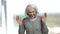 Funny senior woman is laughing on blurred background.