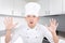 Funny shocked man in chef uniform in white modern kitchen