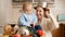 Funny shot of mother and little baby boy playing with pans and cookware on kitchen