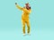 Funny showman in yellow suit and rubber pink horse mask dancing on turquoise background.