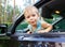 Funny small kid looking from open car window