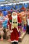 Funny smiling Santa Claus in red cap, beautiful New Year and Christmas toy, decorations and gifts. Festive Christmas winter