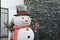 Funny snowman near house. Festive outdoor Christmas decoration