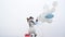 Funny snowman outdoor. Happy fun snowman hold balloons on white snow background. The snowman is wearing a fur hat and