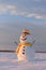 Funny snowman in yellow hat