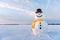 Funny snowman in yellow hat