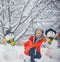 Funny snowmen. Merry Christmas and Happy Holidays. Christmas preparation - funny girl make snowman. Snowman and funny