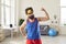 Funny sportsman boasting his thin, weak arm muscles after sport workout at home