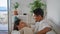 Funny spouses joking hotel closeup. Gentle man caresses wife relaxing soft couch