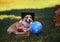 Funny student the Corgi dog puppy sits in a Sunny autumn garden in green grass with books and a globe in a black Confederate hat