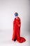 Funny superhero child in red cape and blue mask