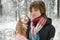 Funny teen sisters having fun on a walk in snow covered pine forest on chilly winter day. Teenage girls exploring nature