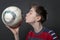 Funny teenage boy is kissing a soccer ball