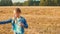 Funny teenager girl blowing soap bubbles on wheat field landscape