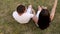 Funny teenagers couple in love lie on the grass in the summer park holding hands