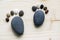 Funny tiny stone feet and ten toes on wooden background, stone in the shape of a human feet