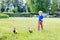 Funny toddler boy chasing wild ducks in a park