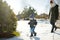 Funny toddler boy and his big teenage sister having fun outdoors on chilly winter day. Children exploring nature