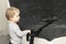 Funny toddler cleaning up the sofa with vacuum cleaner