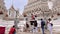 Funny tourist man posing near sculpture on steps of