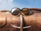 Funny travel face from an old brown suitcase with sunglasses and a painted mouth against a blue sky with clouds, copy space,