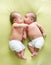 Funny twins brothers babies lying on green bed