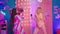 Funny two best friends ladies have a fun time together in the bedroom listening music from a big pink box and dancing at