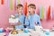 Funny two brothers enjoying dessert, isolated pink background, studio shot