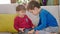 Funny two little kids brothers spending lovely time together while using the smartphone they playing together on the