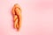 funny ugly twisted carrot on pink background.