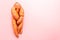 Funny ugly twisted carrot on pink background