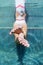 Funny underwater photo of young woman relaxing in swimming pool