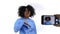 Funny vlogger woman with afro hair recording video of herself dancing in front of smartphone camera on white background