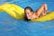 Funny woman bathing in a pool playing with a mattress