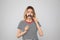 Funny woman with fake mustache on grey background