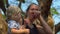 Funny woman feed a giraffe holding a peace of carrot in her lips in a safari park