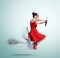 Funny woman in red flying on the toilet with steering wheel. Concept of movement