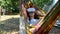 funny woman wearing virtual reality glasses rests in a hammock near a tree, imagining a dream come true, an invented