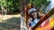 funny woman wearing virtual reality glasses rests in a hammock near a tree, imagining a dream come true, an invented