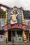 Funny wooden cowboy with pistol and horse figure at amusement park on building facade.